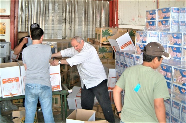 צילום: אפי ריפקין פורת ז"ל באריזת קמחא דפסחא בגוש קטיף, ערב פסח תשס"ד